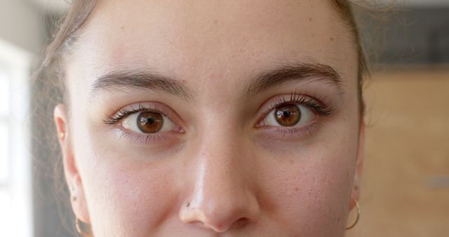 Close-up view of woman's eyes, highlighting natural brown eye color and detailed eyelashes. Perfect for makeup tutorials, skincare advertisements, eye color product promotions, or as a part of a portfolio highlighting facial features or natural beauty.