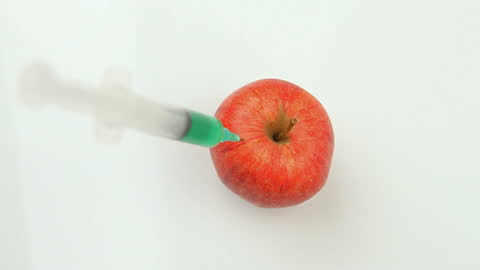 Concept of GMO and Chemical Injection in Red Apple