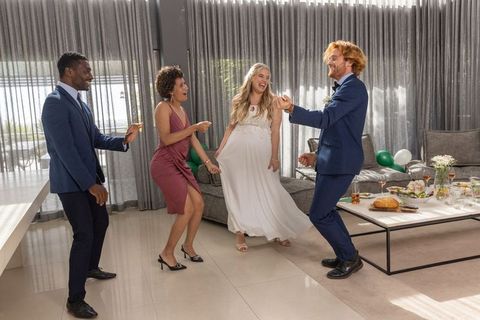 Diverse friends celebrating in luxury living room in formal attire