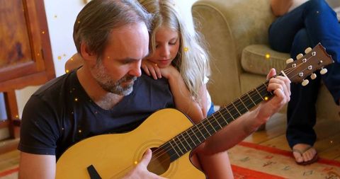 Father Playing Acoustic Guitar with Daughter for Family Bonding