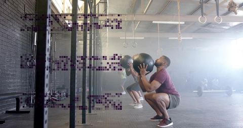 Fitness Enthusiasts Training with Medicine Balls in Industrial Gym