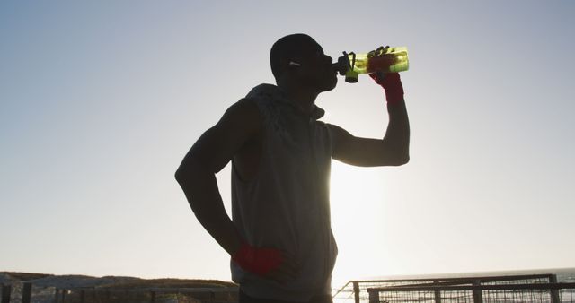 Athletic man hydrating after outdoor workout at sunrise - Download Free Stock Images Pikwizard.com