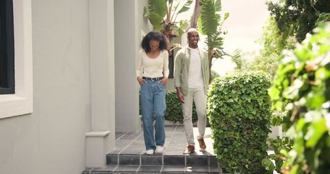 Couple enjoying stroll on elegant patio amid lush garden