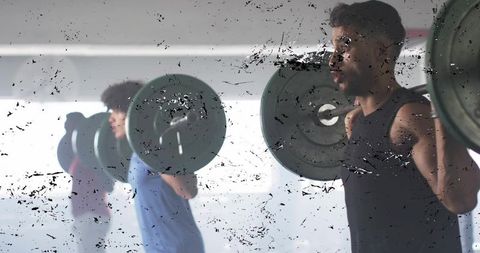 Squatting athletes lifting heavy barbells in gym, strength training and teamwork focus