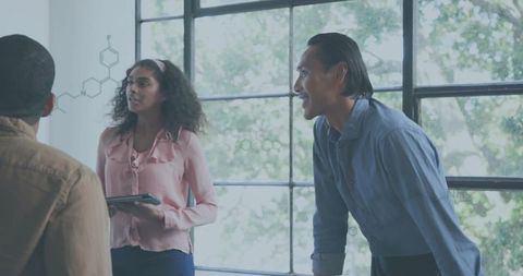 Presenting team discussing chemical diagrams with tablet in bright modern office teamwork