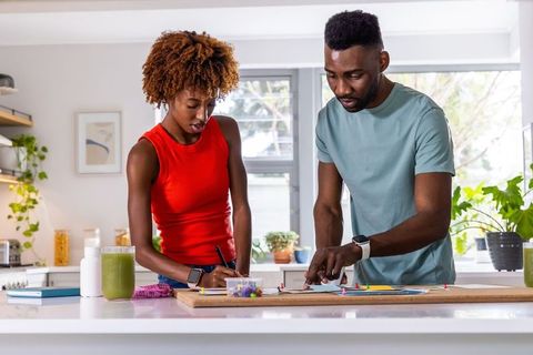 African american couple planning home project together at bright kitchen island