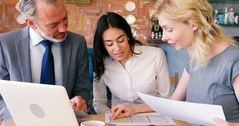 Business Team Collaborating Over Coffee in Cafe