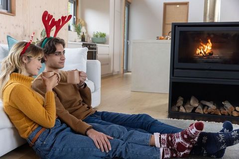 Couple Enjoying Cozy Winter Scene by Fireplace with Mugs