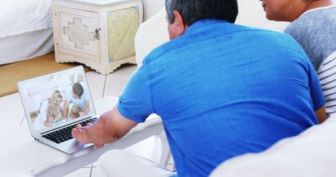 Elderly Couple Video Calling Family on Laptop