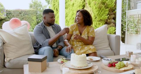 Happy Couple Toasting With Champagne on Sunny Patio