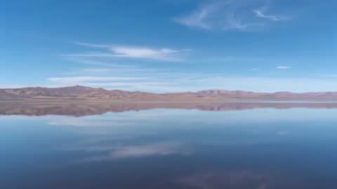 Aerial Video Showing Mirror-Like High-Plain Lake Reflecting Cirrus Clouds and Ridges