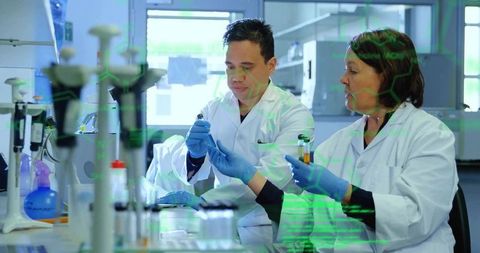 Researchers collaborating on pipetting and vial handling in clinical biotechnology laboratory