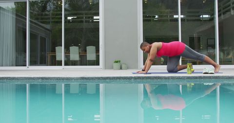Energetic Woman Practicing Yoga by Swimming Pool