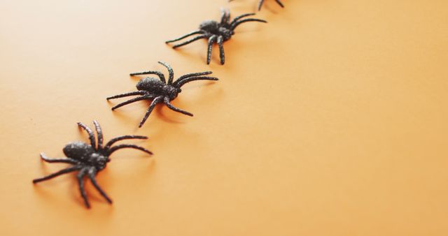 Close up of multiple spider toys with copy space against orange background - Download Free Stock Photos Pikwizard.com