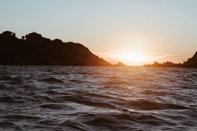 Serene Sunset Over Rocky Coastline and Calm Sea - Download Free Stock Photos Pikwizard.com