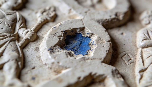 Weathered carved relief revealing cobalt blue pigment macro detail for conservation use