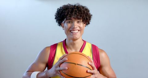 Young Biracial Basketball Player Holding Basketball Smiling Brightly - Download Free Stock Images Pikwizard.com