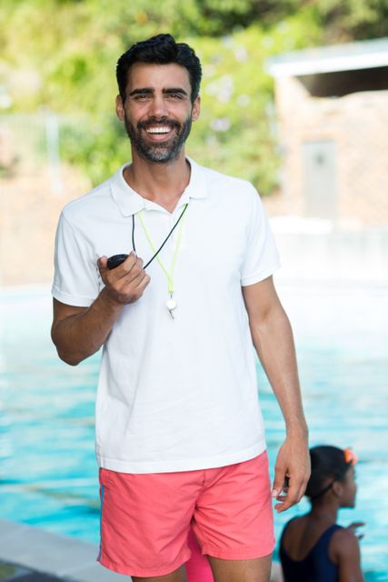 Portrait of male instructor standing at poolside