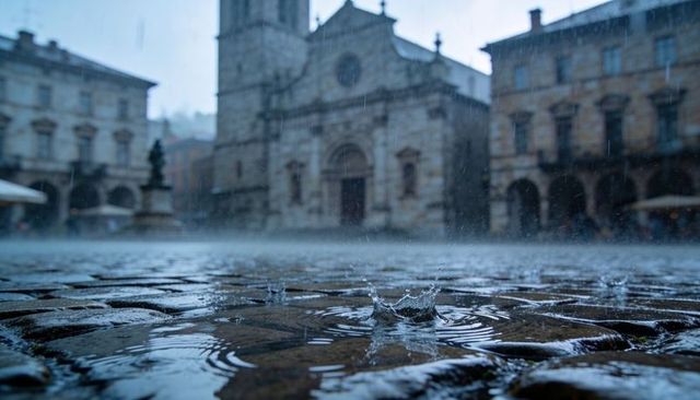 Raindrop splash on wet cobblestone plaza with historic stone church and arcades