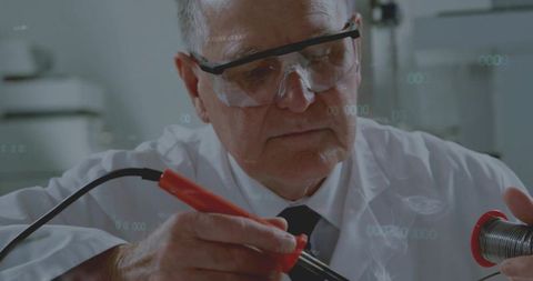 Elderly Technician Expertly Using Soldering Iron in Laboratory