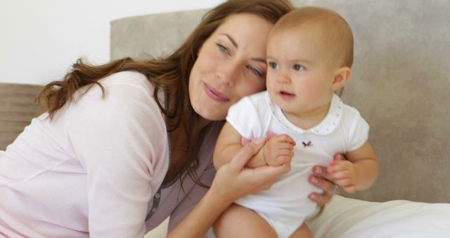 Mother Hugging Her Baby on Bed in Cozy Bedroom - Download Free Stock Images Pikwizard.com