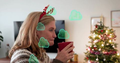Woman holding red mug wearing reindeer headband enjoying cozy christmas living room
