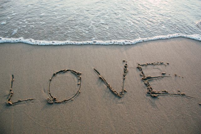 Love Written on Sandy Beach with Ocean Waves Gently Approaching - Download Free Stock Photos Pikwizard.com