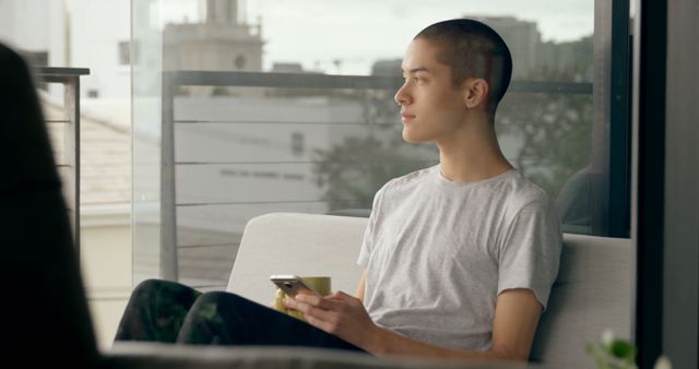 Young Man Relaxing and Distracts With Smartphone in Modern Apartment - Download Free Stock Images Pikwizard.com