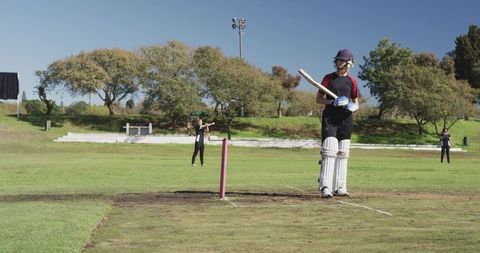 Women Cricket Players Walking Across Field on Sunny Day