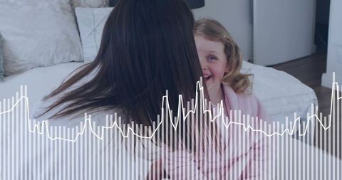 Mother and daughter laughing on bed in bedroom, pink bathrobe with waveform overlay