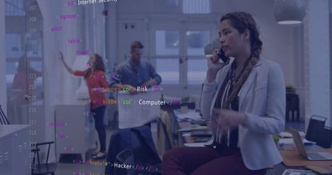 Businesswoman talking on phone while sitting on desk with code overlay in modern office