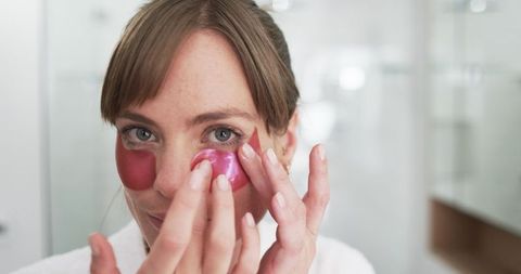 woman using under-eye patches for skincare routine at home - Download Free Stock Images Pikwizard.com