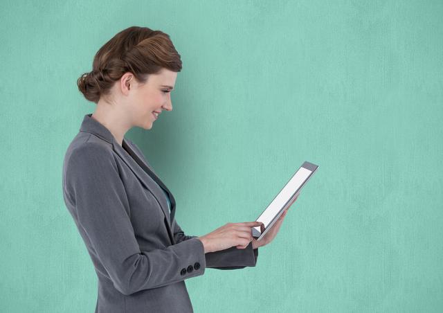 Businesswoman using a tablet PC with a blank screen against a teal background. Perfect for themes related to technology, business, corporate presentations, modern work environments, and professional services.