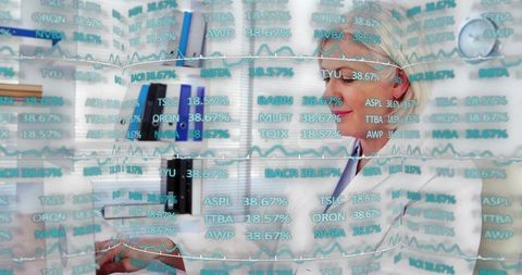 Female clinician reviewing patient paperwork with cyan financial data overlay in clinic