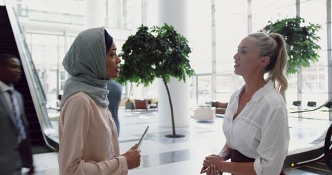 Diverse businesswomen engaged in corporate lobby discussion