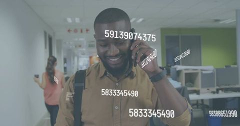 Businessman walking through office corridor talking on phone with floating data overlays