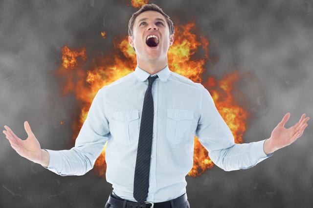 Digital composite of Angry businessman screaming with fire in background