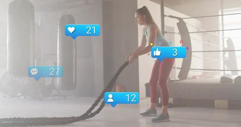 Woman Training with Battle Ropes in Boxing Gym Displaying Social Media Reactions