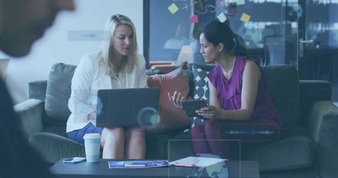 Businesswomen Collaborating in Modern Office Lounge with Technology