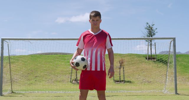 Confident Soccer Player Holding Ball on Field by Goalpost - Download Free Stock Images Pikwizard.com