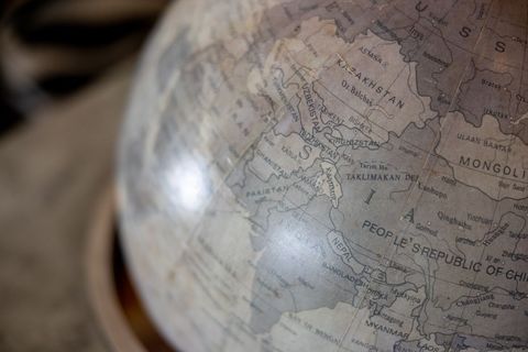 Vintage globe showing central and south asia map detail with muted neutral tones and antique cartogr