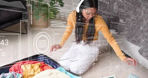 Packing luggage with holographic interface: woman organizing outfits using tablet