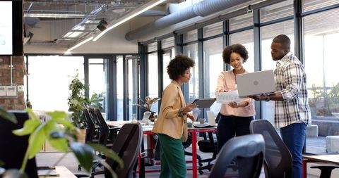 Diverse Business Colleagues Discuss Data in Modern Office