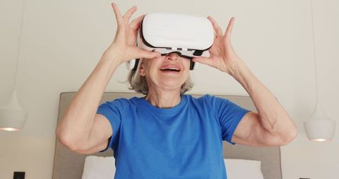 Senior Woman Enjoying Virtual Reality in Modern Bedroom