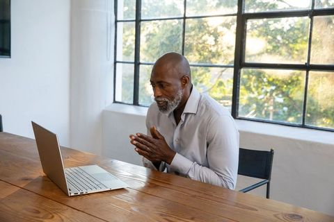 Senior Man Focusing on Laptop in Bright Workspace