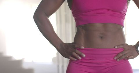 Woman in Pink Activewear Showing Fit Physique in Gym