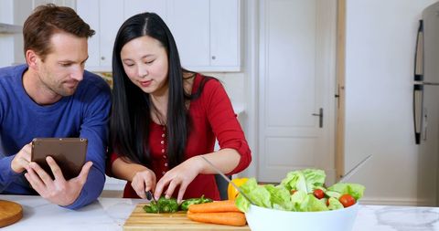 Couple Cooking While Following Tablet Recipe at Home Kitchen
