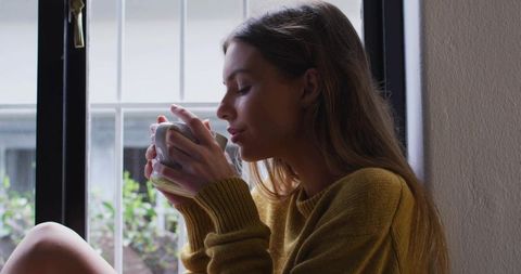 Peaceful Woman Savoring Coffee Overlooking Serene Greenery