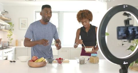 Filming and preparing vibrant smoothie bowls on modern kitchen island for recipe content