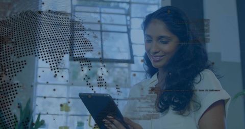 Woman using tablet with global data overlay in modern office for data analytics